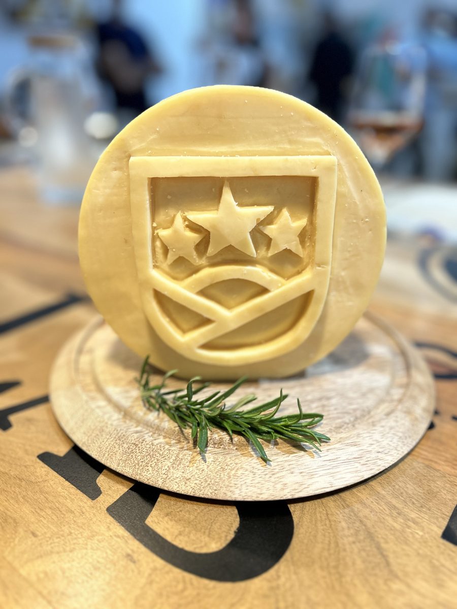 Queso tallado con el escudo de Lácteos Las Tres